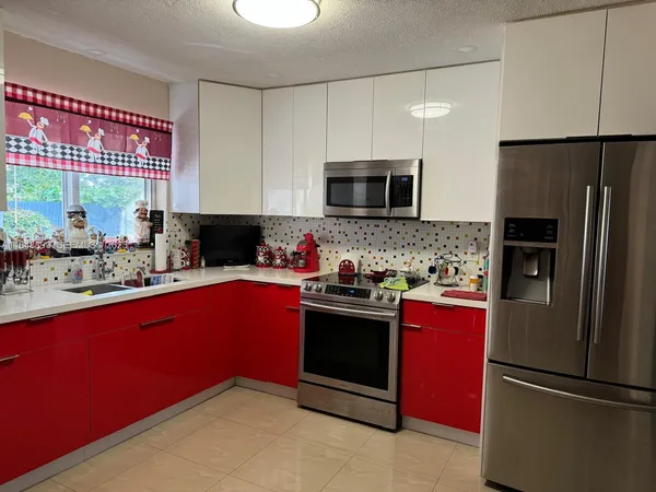 a kitchen with stainless steel appliances granite countertop a refrigerator stove a sink dishwasher and microwave