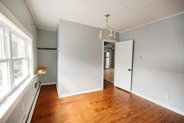 a view of a hallway with wooden floor and a window
