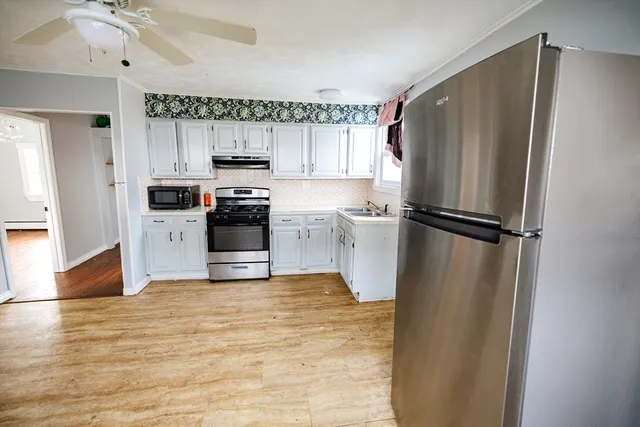 a kitchen with a refrigerator and a stove top oven