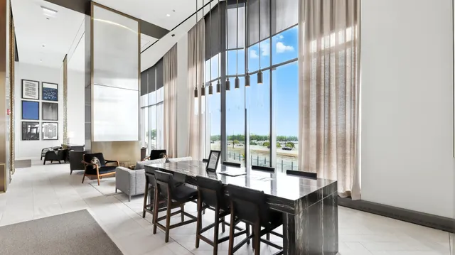a dining room with furniture and large windows