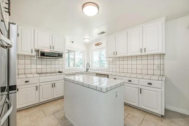 a kitchen with a sink stove and cabinets