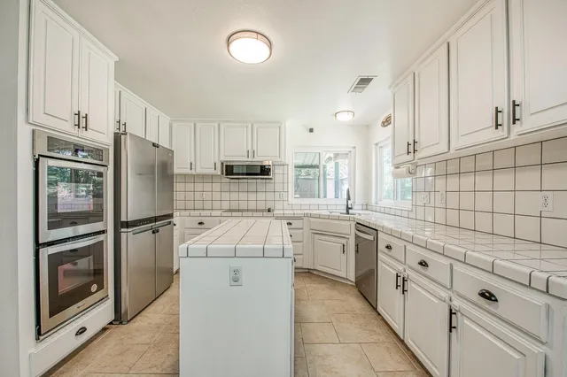 a kitchen with stainless steel appliances a refrigerator sink and cabinets