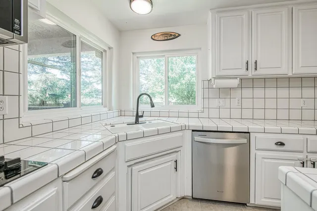 a kitchen with white cabinets and white appliances