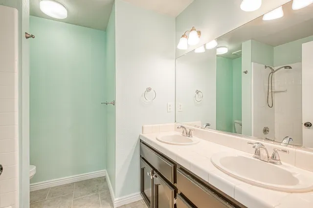 an empty room with windows and a ceiling fan