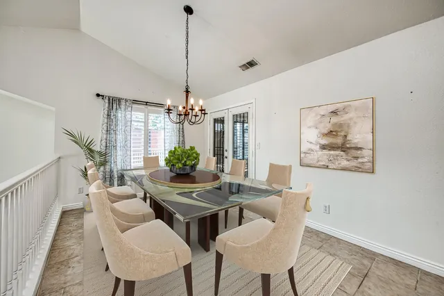 a dining room with furniture a chandelier and wooden floor