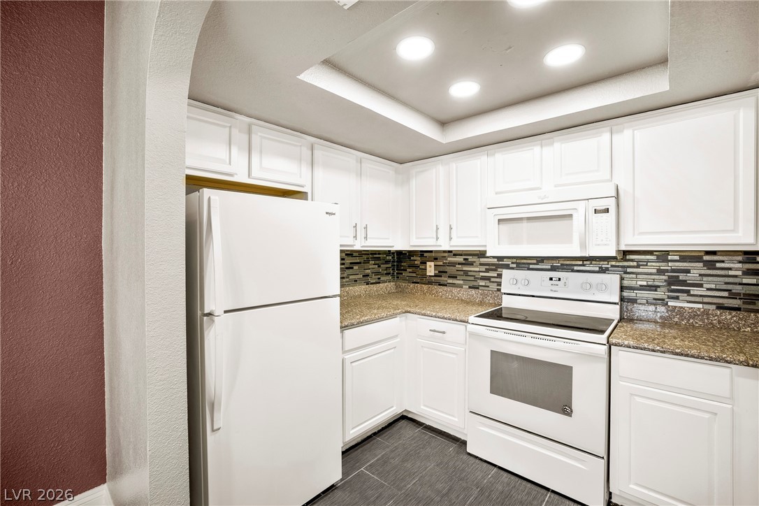 3311 Sunfish Drive, Unit D Henderson, NV 89014 - Photo 4 of 21 A well-equipped kitchen features white cabinetry and sleek countertops.