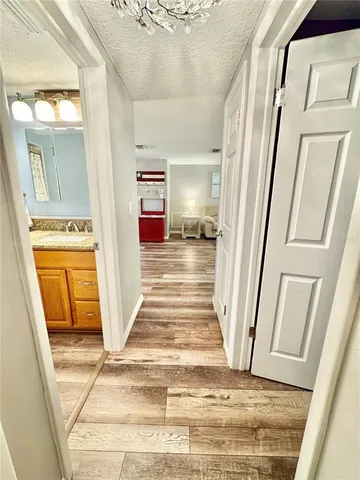 a view of a hallway with a couches and dining table with wooden floor