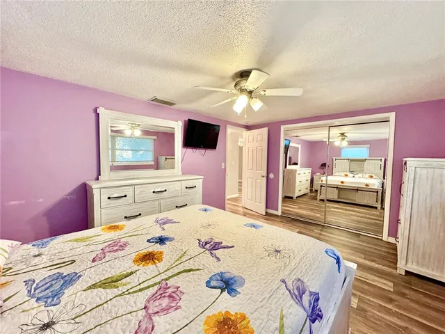 a bedroom with a bed and a large mirror with a dresser