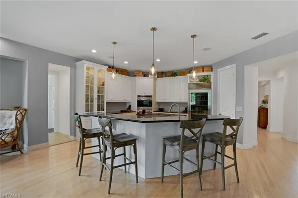 a kitchen with a dining table chairs sink and cabinets