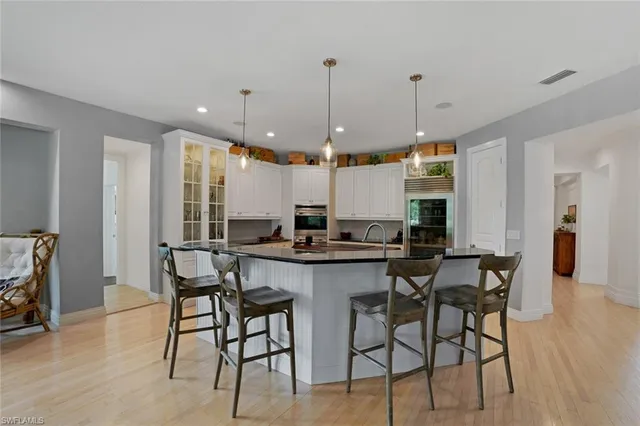 a kitchen with a dining table chairs sink and cabinets