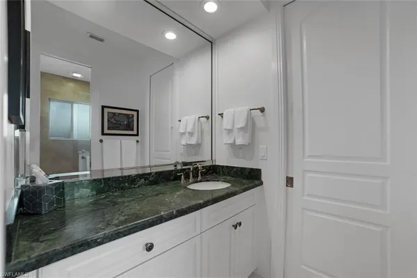 a bathroom with a granite countertop sink and a mirror