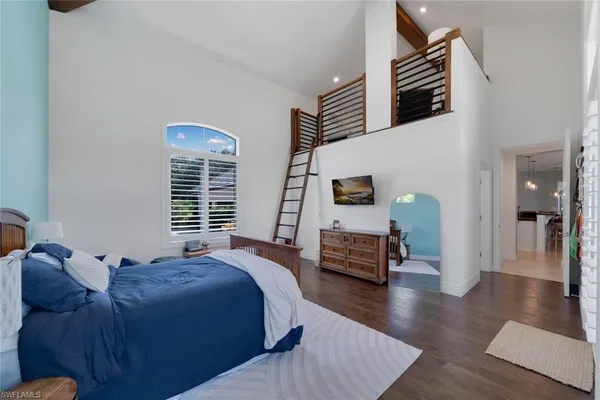 a spacious bedroom with a bed and wooden floor