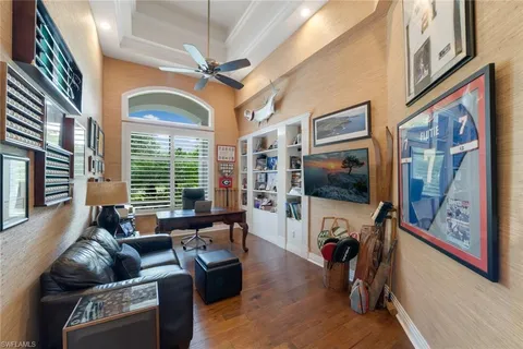 a living room with furniture a flat screen tv and a floor to ceiling window