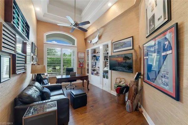 a living room with furniture a flat screen tv and a floor to ceiling window