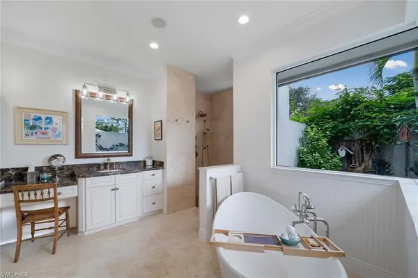 a en suite bathroom with a granite countertop sink and a large mirror
