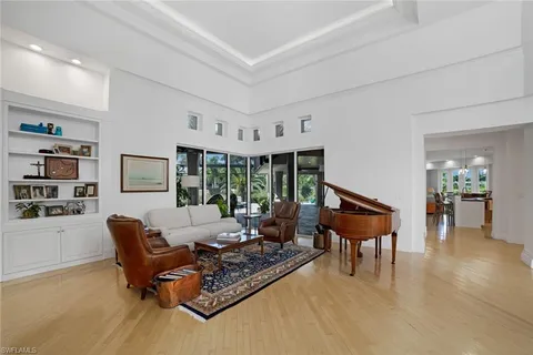 a living room with furniture large window and wooden floor