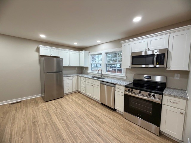 417 Laura Avenue Winchester, TN 37398 - Photo 6 of 18 a kitchen with stainless steel appliances granite countertop a refrigerator a stove top oven a sink and dishwasher with wooden floor