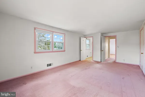 an empty room with windows and closet