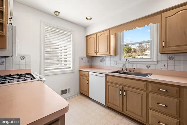 a kitchen with cabinets appliances a sink and a window