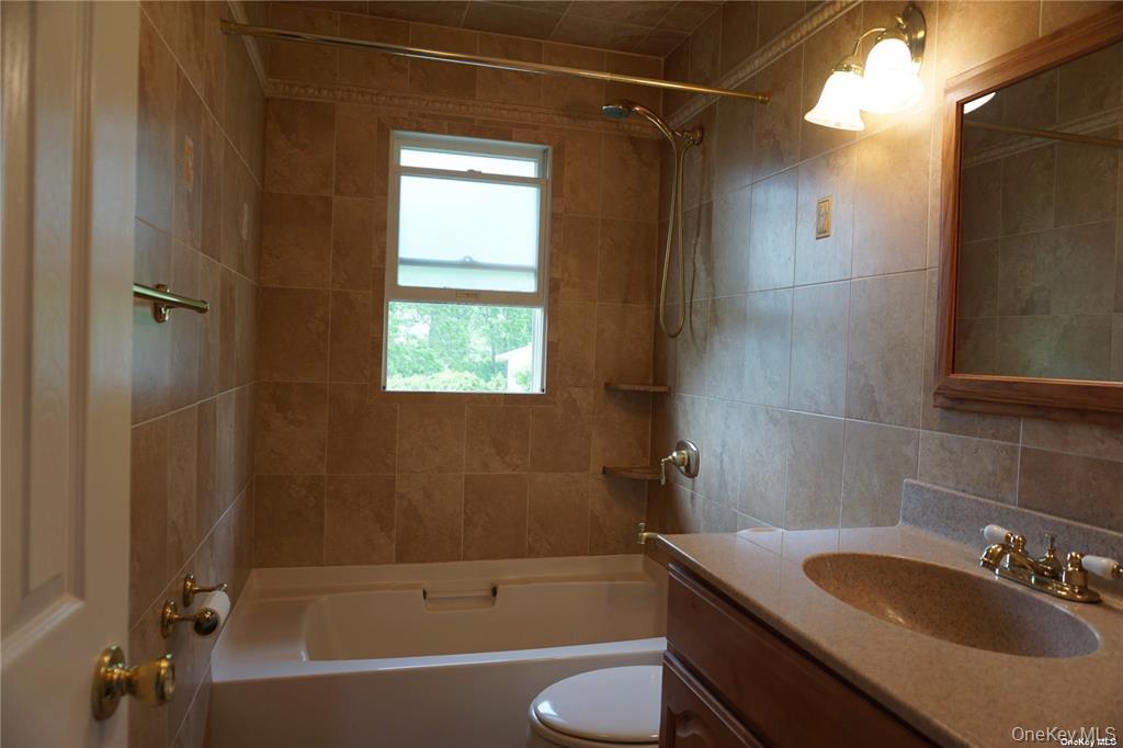 15 Reed Drive Deer Park, NY 11729 - Photo 9 of 12 a bathroom with a sink toilet and shower