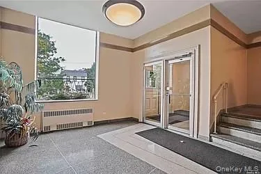 a view of a hallway with a large window and chandelier