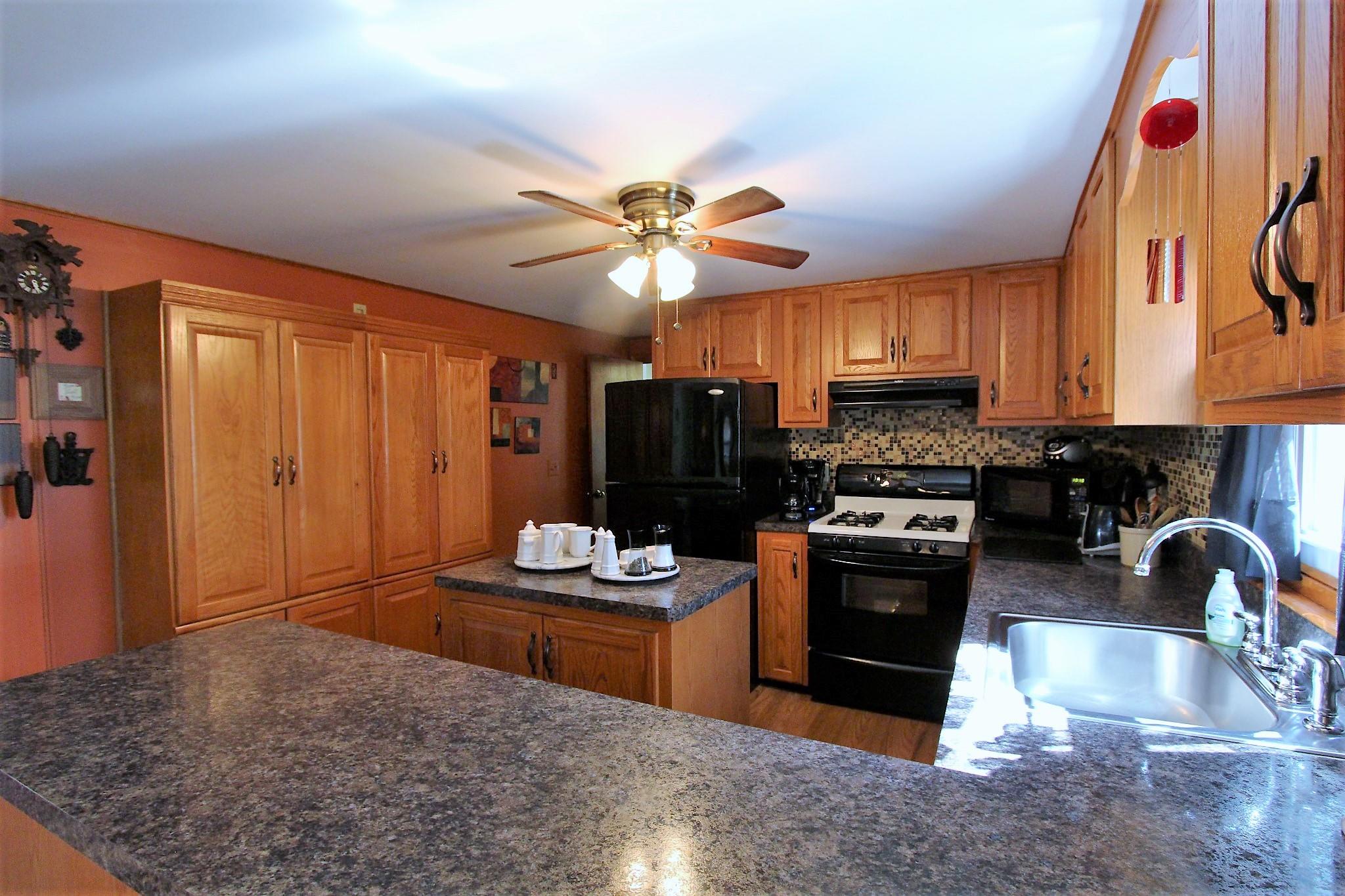 35 Tuckernuck Road Centerville, MA 02632 - Photo 21 of 28 a kitchen with stainless steel appliances granite countertop a stove refrigerator and cabinets