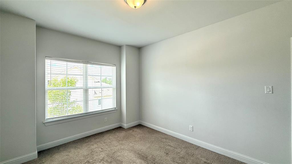 601 C-Bar Ranch Trail, Unit 27 Cedar Park, TX 78613 - Photo 18 of 29 Bright room featuring a large window with horizontal blinds, neutral wall tones, textured carpet flooring, white baseboards, and a semi-flush mount ceiling light