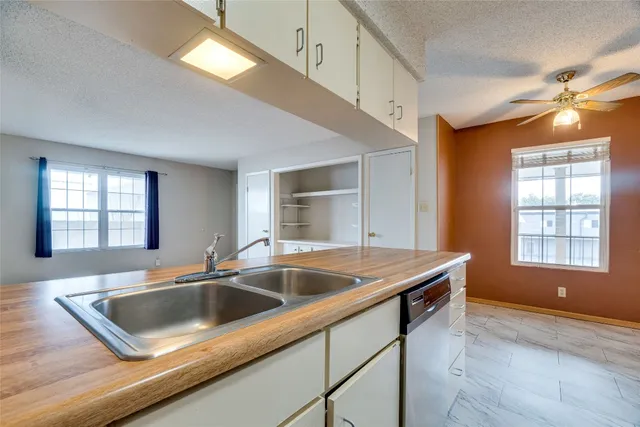 a view of an empty room and chandelier fan