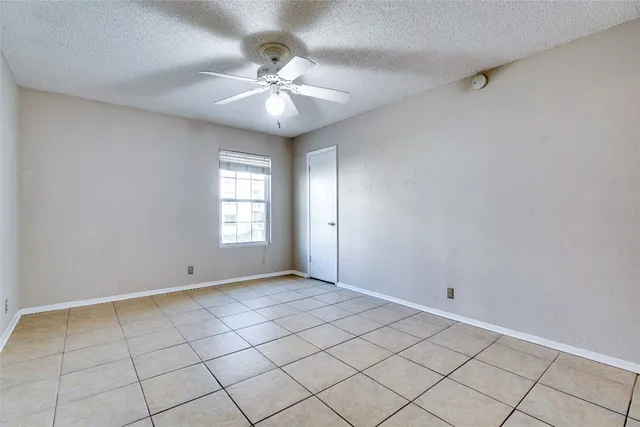 a view of an empty room with chandelier fan