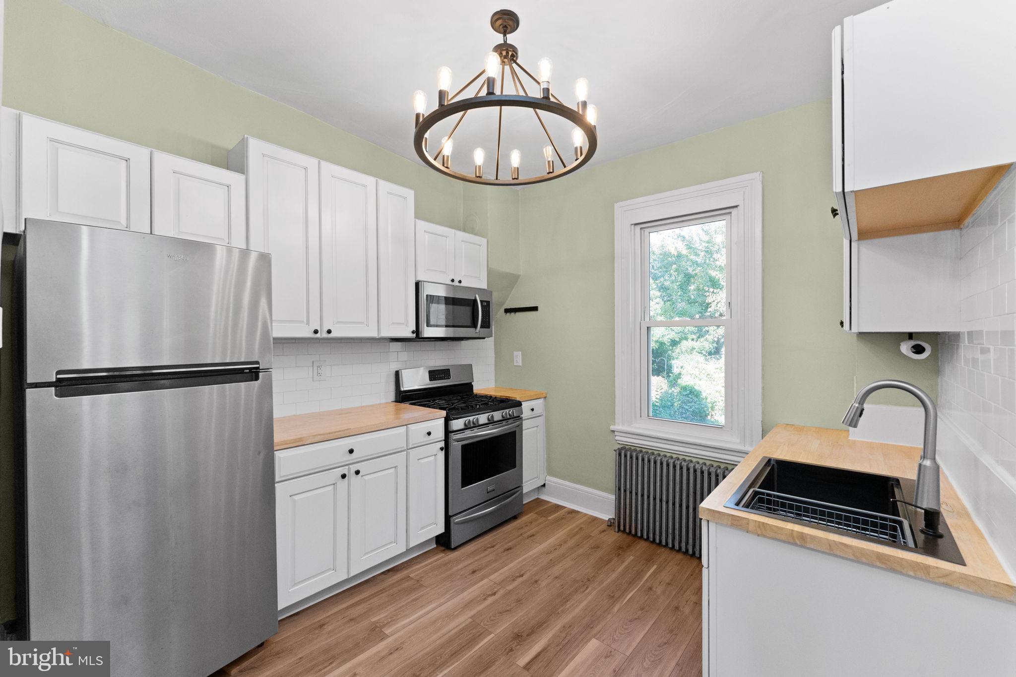 345 Hall Street Phoenixville, PA 19460 - Photo 11 of 32 a kitchen with white cabinets and stainless steel appliances