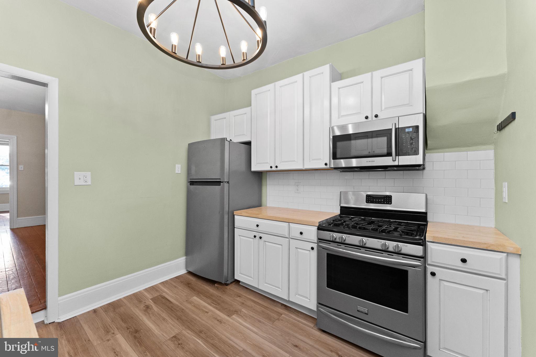 345 Hall Street Phoenixville, PA 19460 - Photo 12 of 32 a kitchen with stainless steel appliances a stove a microwave and cabinets
