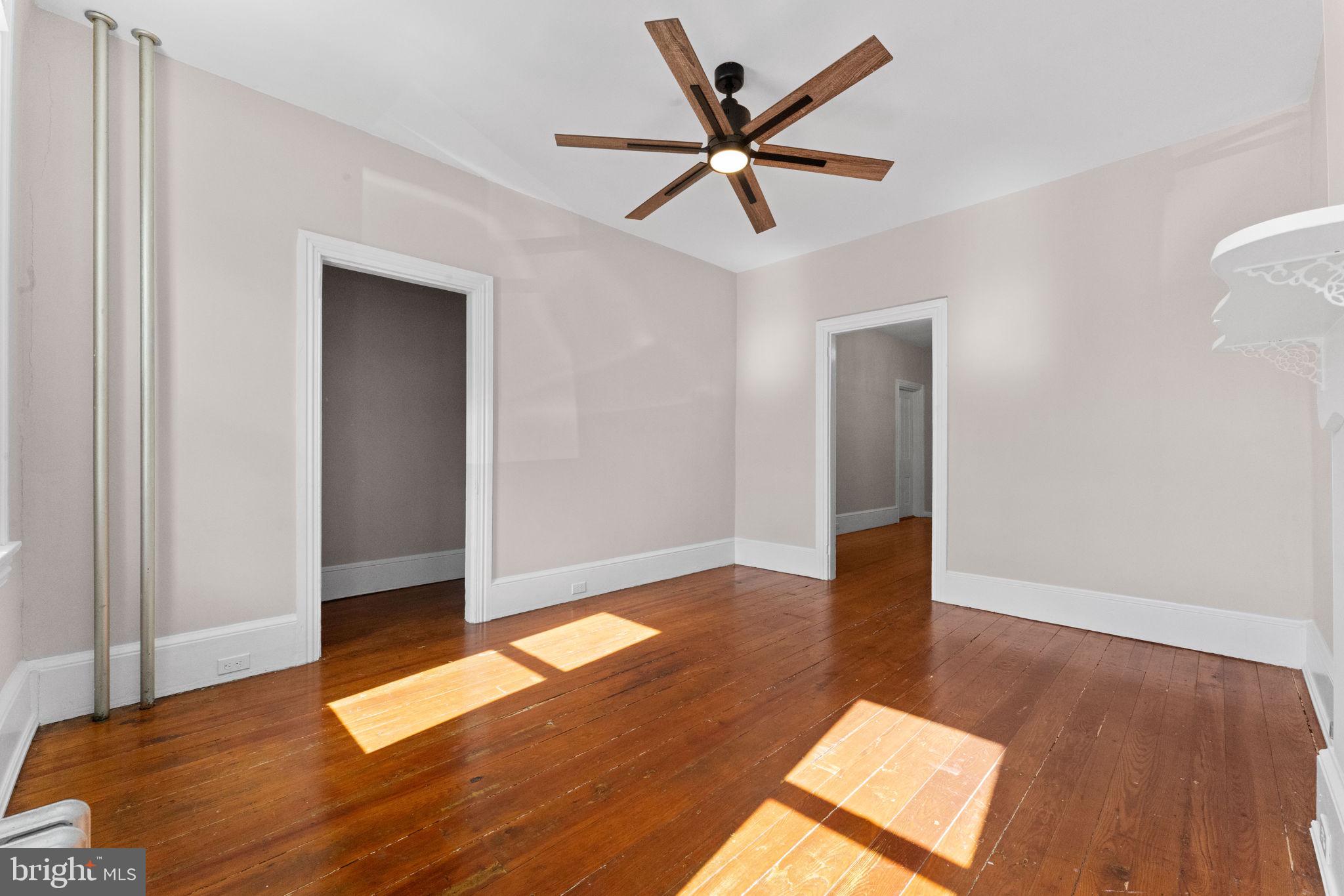 345 Hall Street Phoenixville, PA 19460 - Photo 7 of 32 a view of a big room with wooden floor and a ceiling fan