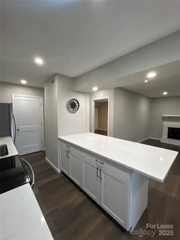 a large white kitchen with sink and natural light