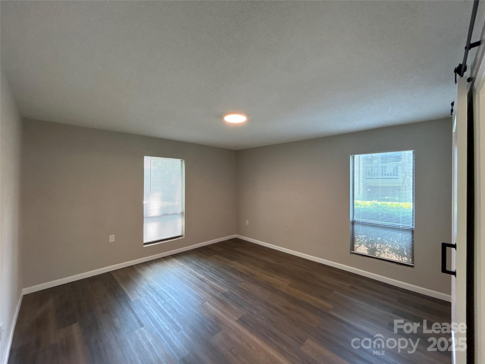 5008 Sardis Road, Unit F Charlotte, NC 28270 - Photo 12 of 19 an empty room with wooden floor and windows