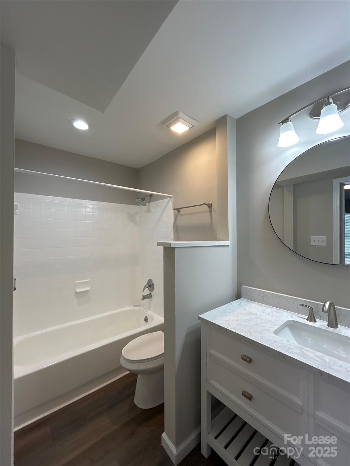 5008 Sardis Road, Unit F Charlotte, NC 28270 - Photo 13 of 19 a bathroom with a toilet a sink a mirror a bathtub and vanity