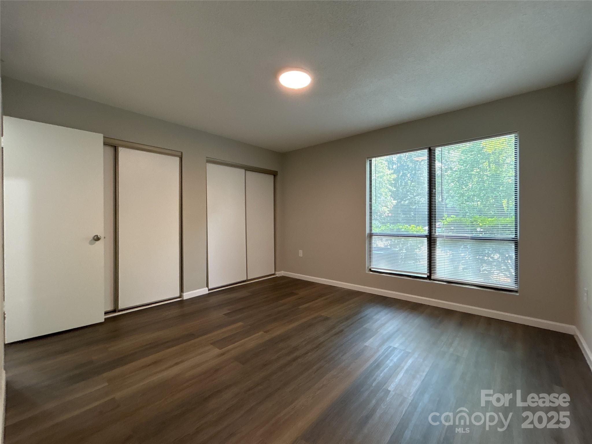 5008 Sardis Road, Unit F Charlotte, NC 28270 - Photo 14 of 19 a view of an empty room with wooden floor and a window