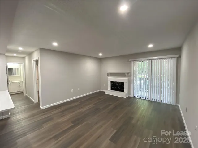 an empty room with wooden floor and fireplace