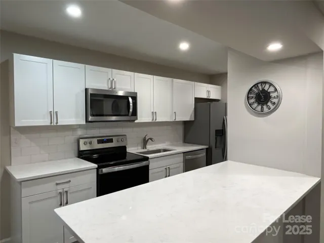 a kitchen with a refrigerator and a stove top oven