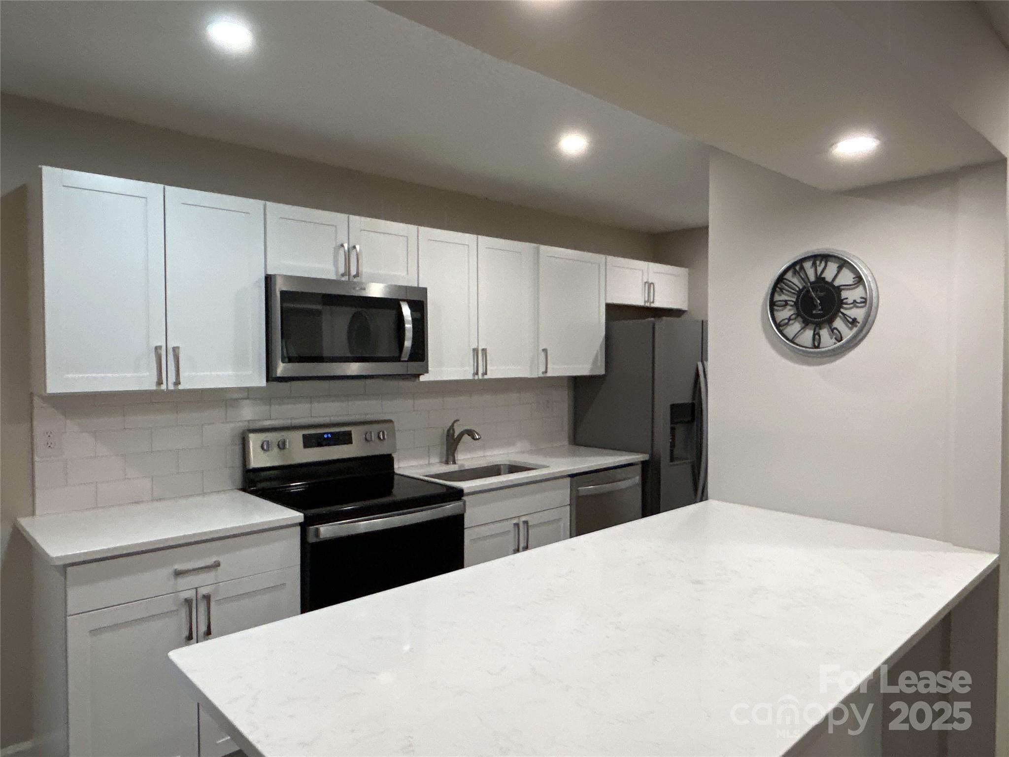 5008 Sardis Road, Unit F Charlotte, NC 28270 - Photo 8 of 19 a kitchen with a refrigerator and a stove top oven