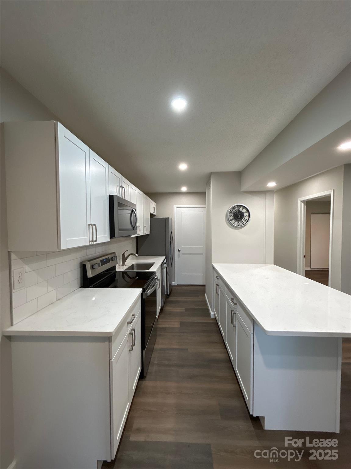 5008 Sardis Road, Unit F Charlotte, NC 28270 - Photo 9 of 19 a large white kitchen with stainless steel appliances