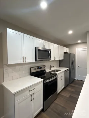 a kitchen with stainless steel appliances a stove a sink dishwasher a refrigerator and a microwave