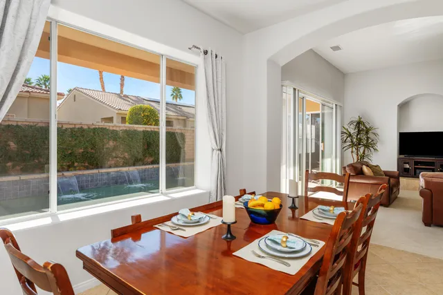 a dining room with furniture and a floor to ceiling window