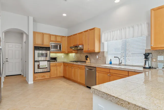 a kitchen with stainless steel appliances granite countertop a sink stove and refrigerator