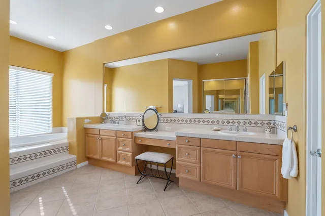 a bathroom with a double vanity sink a mirror and a bathtub