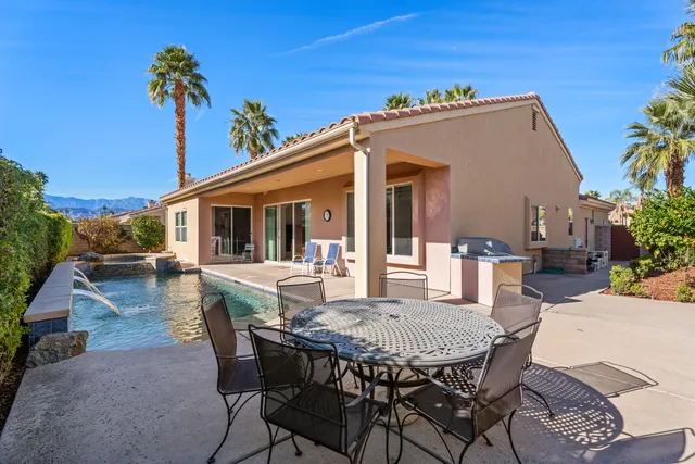 a view of a house with a table and chairs in patio