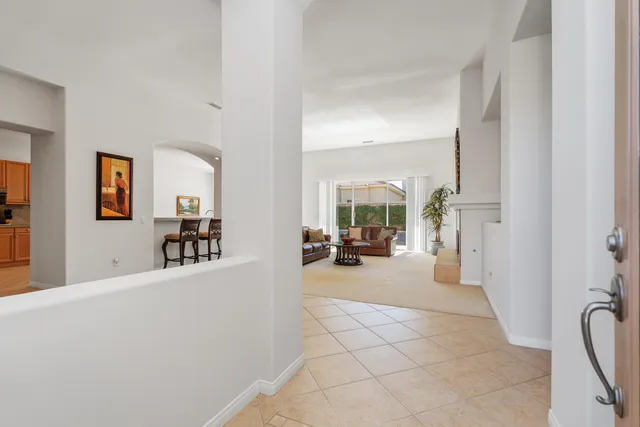 a living room with furniture and a large mirror next to a window