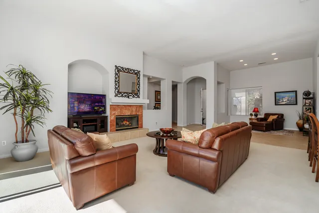 a living room with furniture a fireplace and a potted plant
