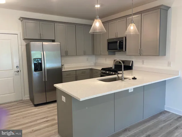 a kitchen with cabinets a sink and stainless steel appliances