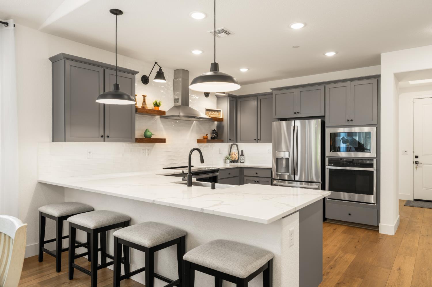 4216 Creede Way Rancho Cordova, CA 95742 - Photo 14 of 56 a kitchen with kitchen island a stove a chandelier and a refrigerator