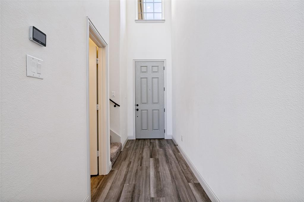 1006 Emil Place Allen, TX 75013 - Photo 4 of 28 Foyer featuring high ceilings, wood-finish flooring, a light gray paneled door, and an upper window providing natural illumination